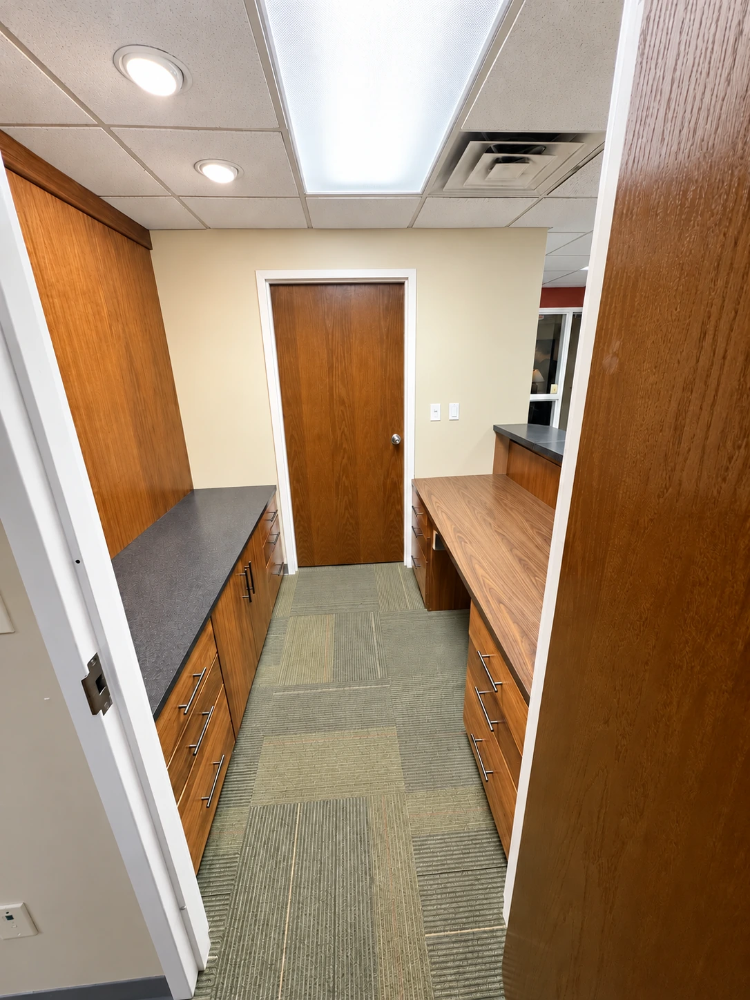 Reception workspace behind the front counter with built-in drawers, cabinets and work surfaces.